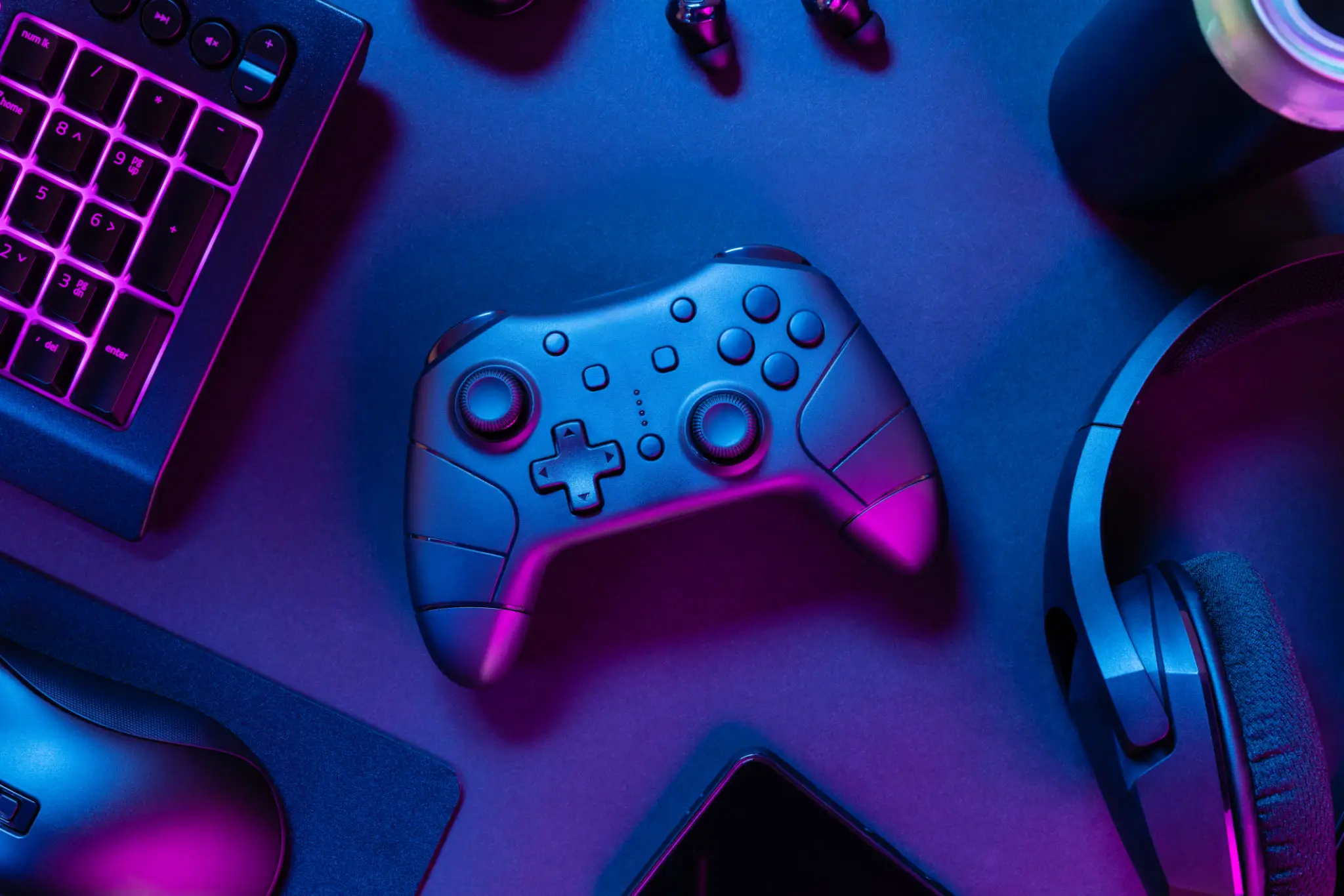 Game controller on neon-lit gaming desk