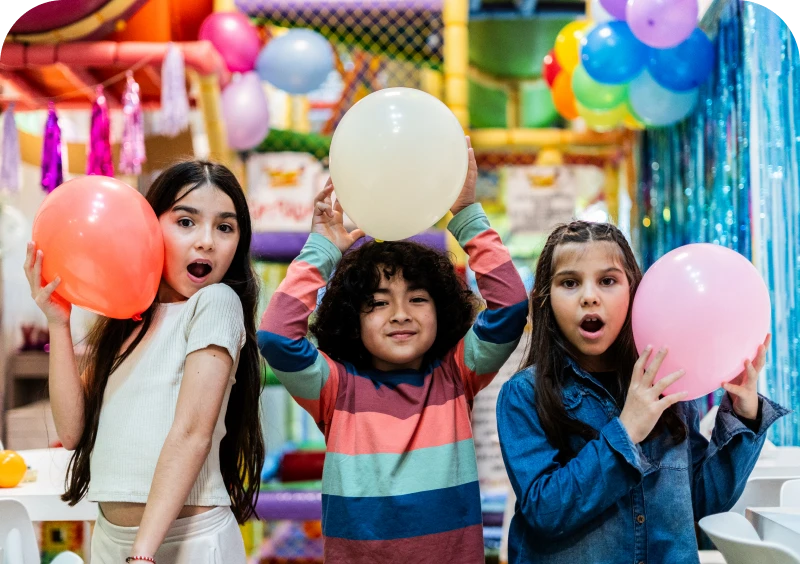 Children holding colorful balloons at party